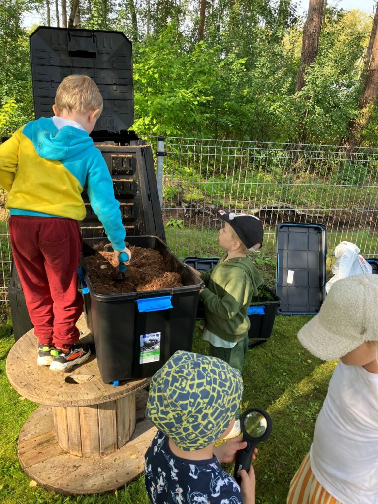 Kompostimise õppepäeval Muuga lasteaias lisasid lapsed kompostrisse turvast.